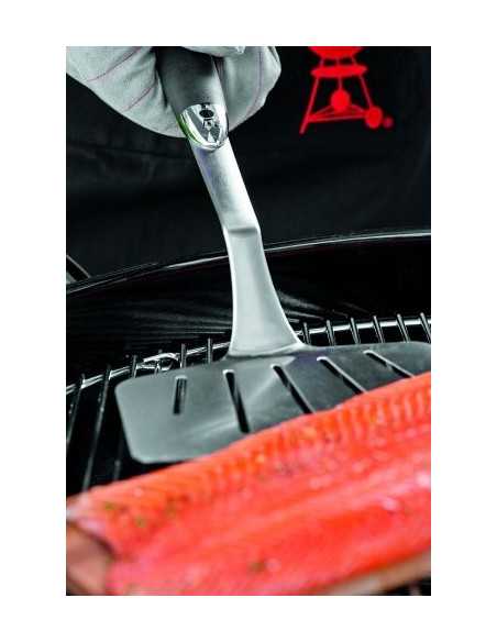 Spatola Weber da pesce in inox mentre gira del salmone su placca di cedro